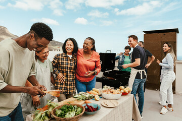 Happy multigenerational people having fun doing barbecue grill at house rooftop - Summer gatherings and food concept - Powered by Adobe