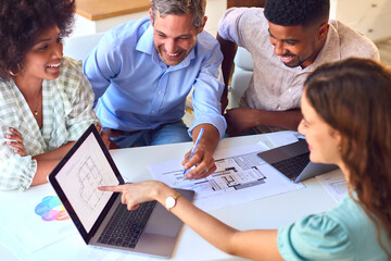 Obraz premium Male And Female Architects With Laptop Meeting And Discussing Building Plans In Modern Office