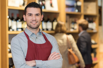 Obraz premium friendly male seller in uniform in wine shop