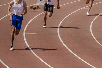 three male athlete runners starting running sprint race, summer athletics championships