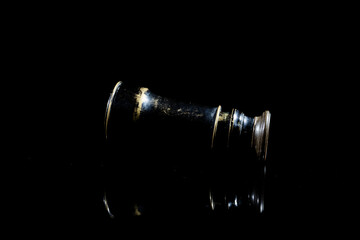 small vintage mono ocular spyglass on black surface with black background