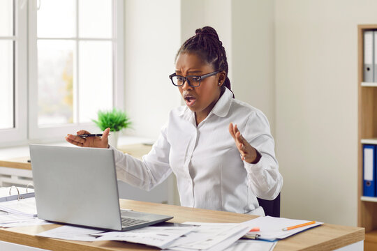 Shocked worried young woman looking at laptop computer screen. Stressed Afro American girl in panic frustrated with computer problem, mistake ,virus, lose data files or negative social media message