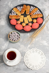 top view cakes and bagels with candies crackers and cup of tea on white background cake biscuit cookie sugar sweet pie