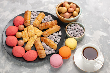 top view delicious cakes with bagels crackers candies and tea on light-white desk cake biscuit cookie sweet sugar pie