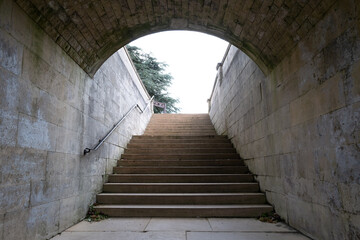 An underground tunnel leading to a wide stairway at a onceEnglish stately home, now a luxury hotel. Wooden stocks can be seen at the top.