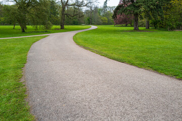 Meandering gravel path seen in the grounds of an English stately home.