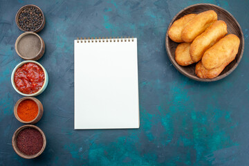 top view delicious pies with meat filling along with seasonings on dark blue background dough pie bread bun food © Kamran