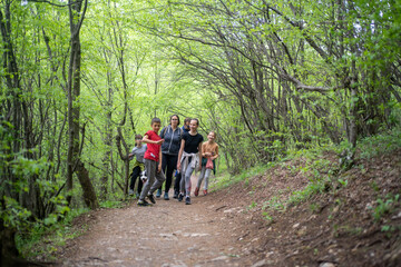 Fototapeta na wymiar happy family with children with backpacks went hiking in forest