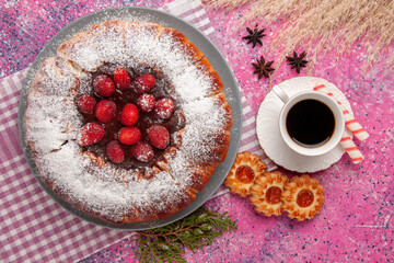 top view delicious strawberry cake sugar powdered with cup of tea and cookies on light-pink...