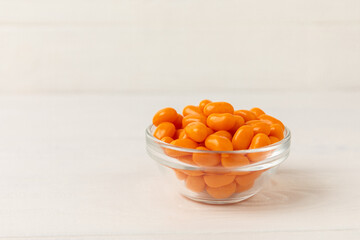 Halloween candy corn with pumpkin flavor on a white background. Classic sweet Halloween candy treats. Halloween holiday concept with candy corn and jack o lantern.