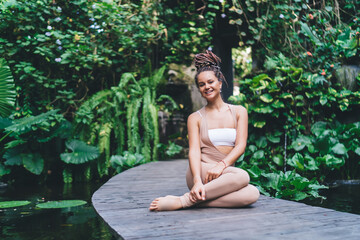 Portrait of cheerful female enjoying time for holistic healing duirn retreat vacations at Bali, happy woman 20 years old keeping healthy lifestyle resting during yoga training and smiling at camera