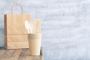 Fototapeta na wymiar Zero waste, plastic free,recyclable, sustainable utensils including fork, spoon, knife, cups, napkin and a bag with copy space. Can be used as a food delivery ad...