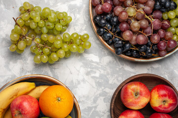 top view different grapes along with other fresh fruits on the light-white desk fruits fresh mellow juice summer