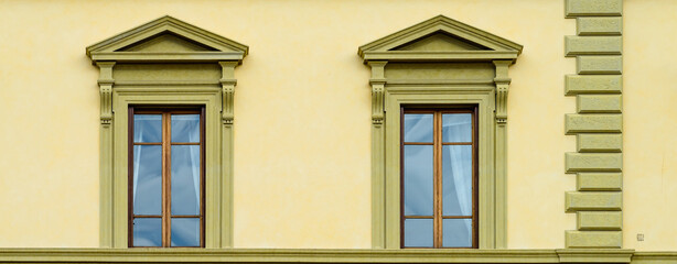 Facade of medieval building with traditional windows in Florence city, Tuscany, Italy. Сlose-up with details
