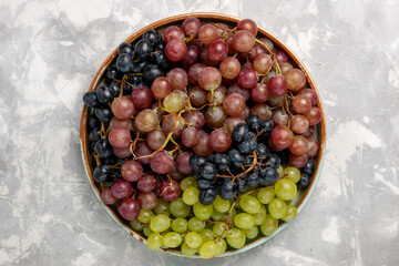 top view different grapes juicy mellow sour fruits on the light white desk fruit fresh mellow juice wine