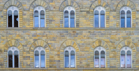 Facade of medieval building with traditional windows in Florence city, Tuscany, Italy. Сlose-up with details