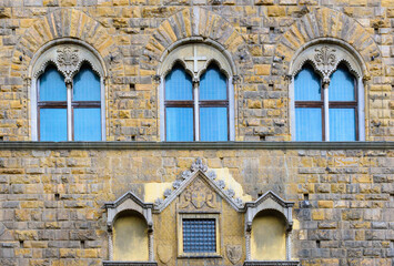 Facade of medieval building with traditional windows in Florence city, Tuscany, Italy. Сlose-up with details
