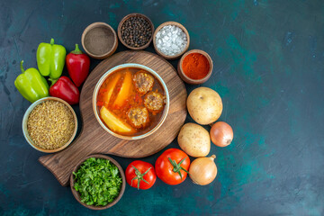 top view meat balls soup with sliced potatoes inside and with fresh vegetables on dark-blue background food soup meat dish dinner vegetable