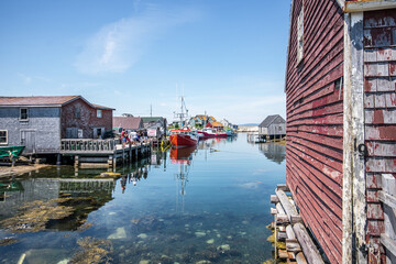 Red boat docked in the bay of a fishing village at Peggy's Cove, Nova Scotia.