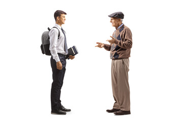Obraz premium Full length profile shot of an elderly man talking to a male teenage student in a school uniform