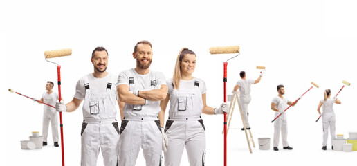 Team of professional painters decorating a wall and posing