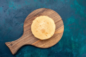 top view plain cake dough baked round formed on the dark blue background cake bake sweet sugar dough pie