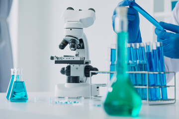 microscope with lab glassware, science laboratory research and development concept
