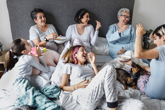 Latin Women Family Grandmother, Mother, Daughter And Children Having Fun On Bed At Home In Latin America, Hispanic Multi Generational Family 	