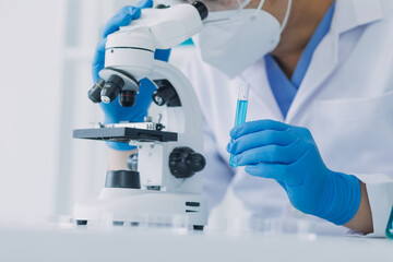 microscope with lab glassware, science laboratory research and development concept