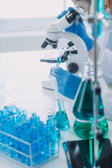 microscope with lab glassware, science laboratory research and development concept