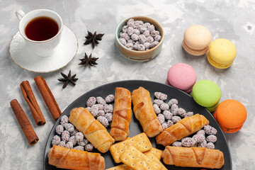 top view yummy cakes with bagels macarons cup of tea and candies on grey white background cake biscuit cookies sugar sweet pie