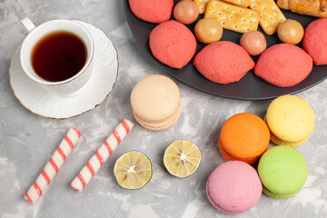 top view yummy cakes with crackers macarons and cup of tea on the grey white desk cake biscuit cookies sugar sweet pie