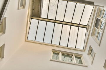 the inside of a building with multiple windows and mirrors hanging from the ceiling to the floor, in an art gallery