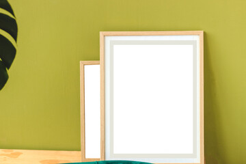 Frame on green wall in interior with place for text.