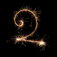 Sparkling burning creative number 2 isolated on black background. Beautiful glowing golden overlay object for design holiday greeting card. Creative lettering number 2 written with burning sparklers