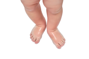 Toddler baby legs is standing in the bathtub, isolated on a white background. Child boy foots washes on the bathroom. Kid age one year
