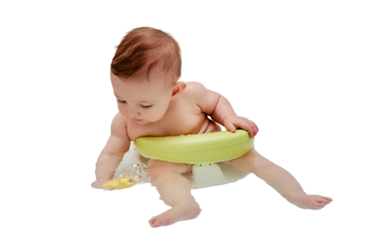 A happy infant baby bathes in water while sitting on a chair in a white tub, isolated on a white background. Toddler child plays with a yellow duck toy while bathing, six to seven months old