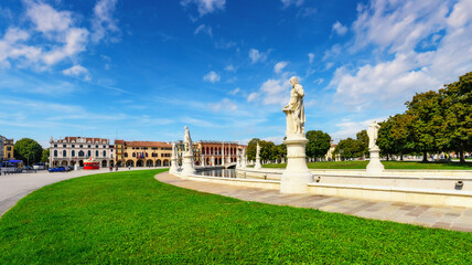 Statues on square Prato della Valle in Padova (Padua), Veneto region, Italy. The largest square in Europe. Sunny day, beautiful sky, soft light. Travel destination in Italy concept.