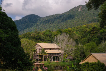Fototapeta na wymiar The traditional heritage Melanau tall house with the blue sky, rainforest landscape, and mountain in Sarawak, Malaysia.