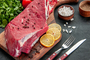 front view raw meat slice with lemon slices and seasonings on dark background cooking butcher dish...