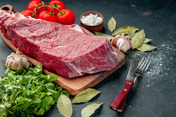 front view raw meat sliced with tomatoes and greens on dark background color food meat barbecue cooking meal butcher