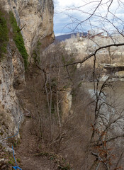 Canyon of a mountain river during the melting of snow, a rapid stream of dirty water rushes to the plain.