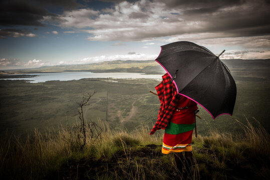 Samburu Warrior in Safari Landscape Under Stormy Sky, Kenya