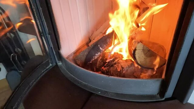 ein Kamin in dem Holz brennt wird ge&ouml;ffnet, in Slow Motion