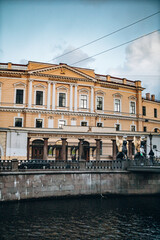 Canal embankment in the city in the evening. Bridges and beautiful buildings. Canal and pleasure boats and boats.