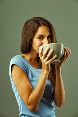 Young woman drinking from large cup