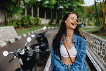 Portrait of a woman brunette smile with teeth walking outside against a backdrop of palm trees in the tropics, summer vacations and outdoor recreation, the carefree lifestyle of a freelance student.