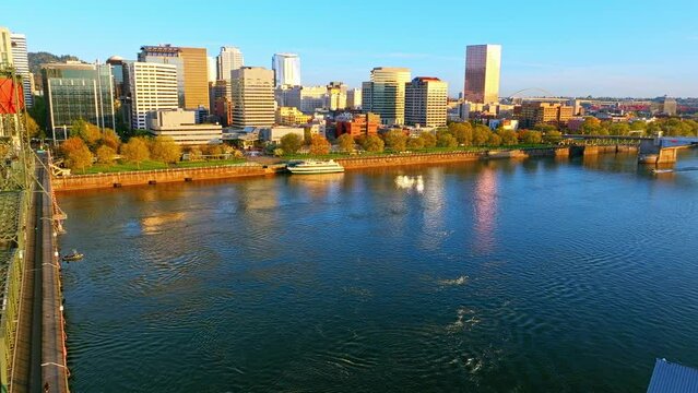 Portland Aerial: Golden Hour, Hawthorne Bridge, speeding boat, and Scenic Bridges & Moda Center in distance in Cityscape