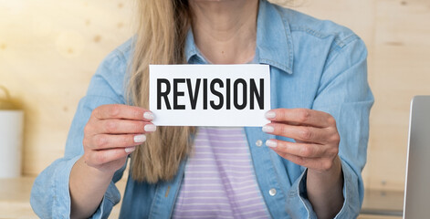 Revision text on card in hands woman. Business concept.