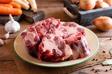 Raw oxtail, the culinary name for the tail of cattle, ready to be cooked. On a wooden board